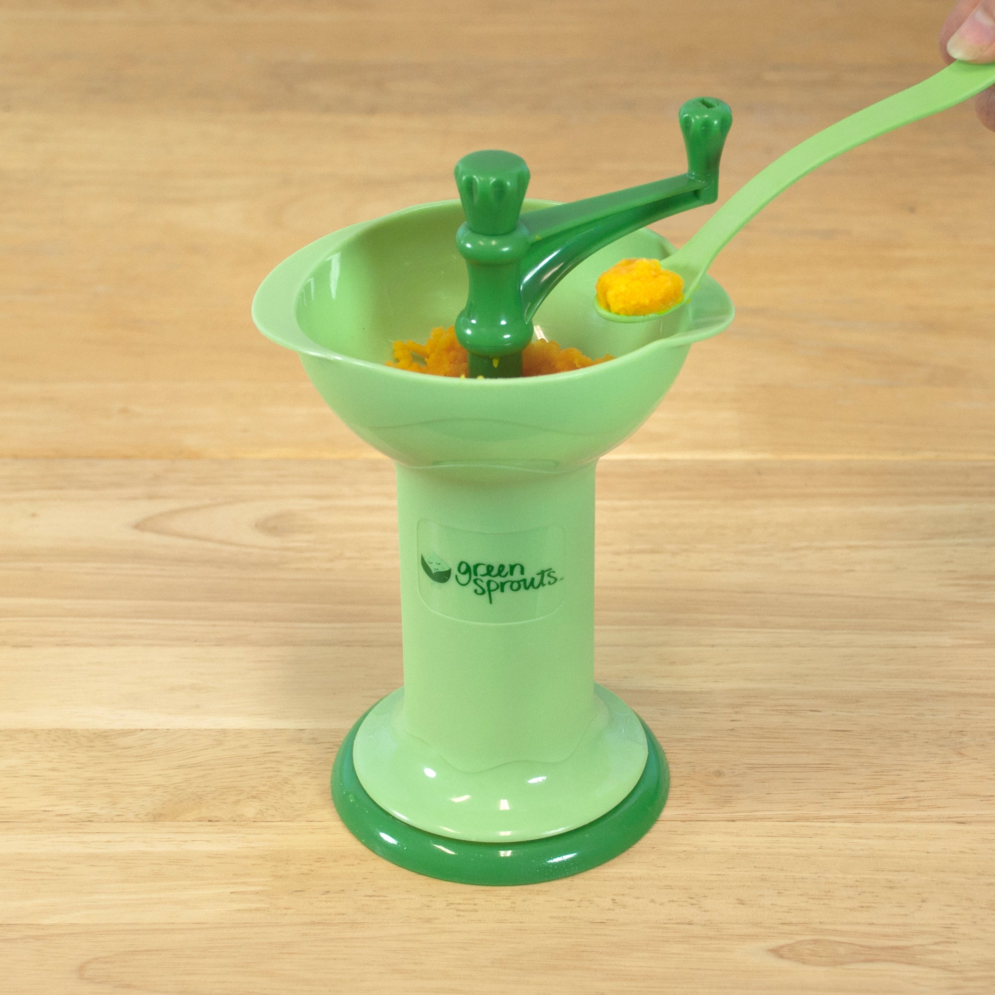 A dipped spoon showing the orange contents that the Fresh Baby Food Mill just grounded up.
