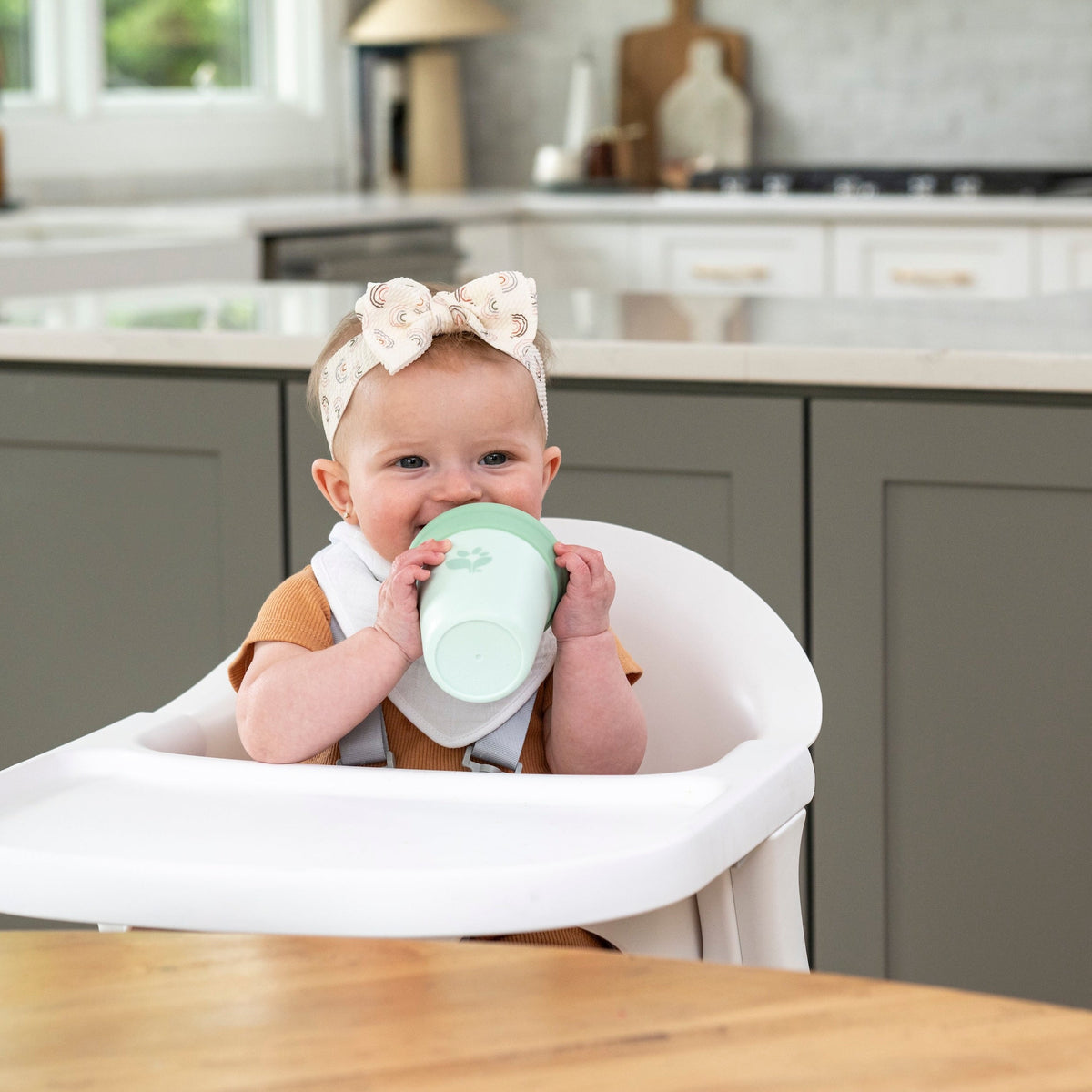 baby smiling and drinking from sippy cup