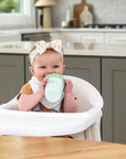 baby smiling and drinking from sippy cup