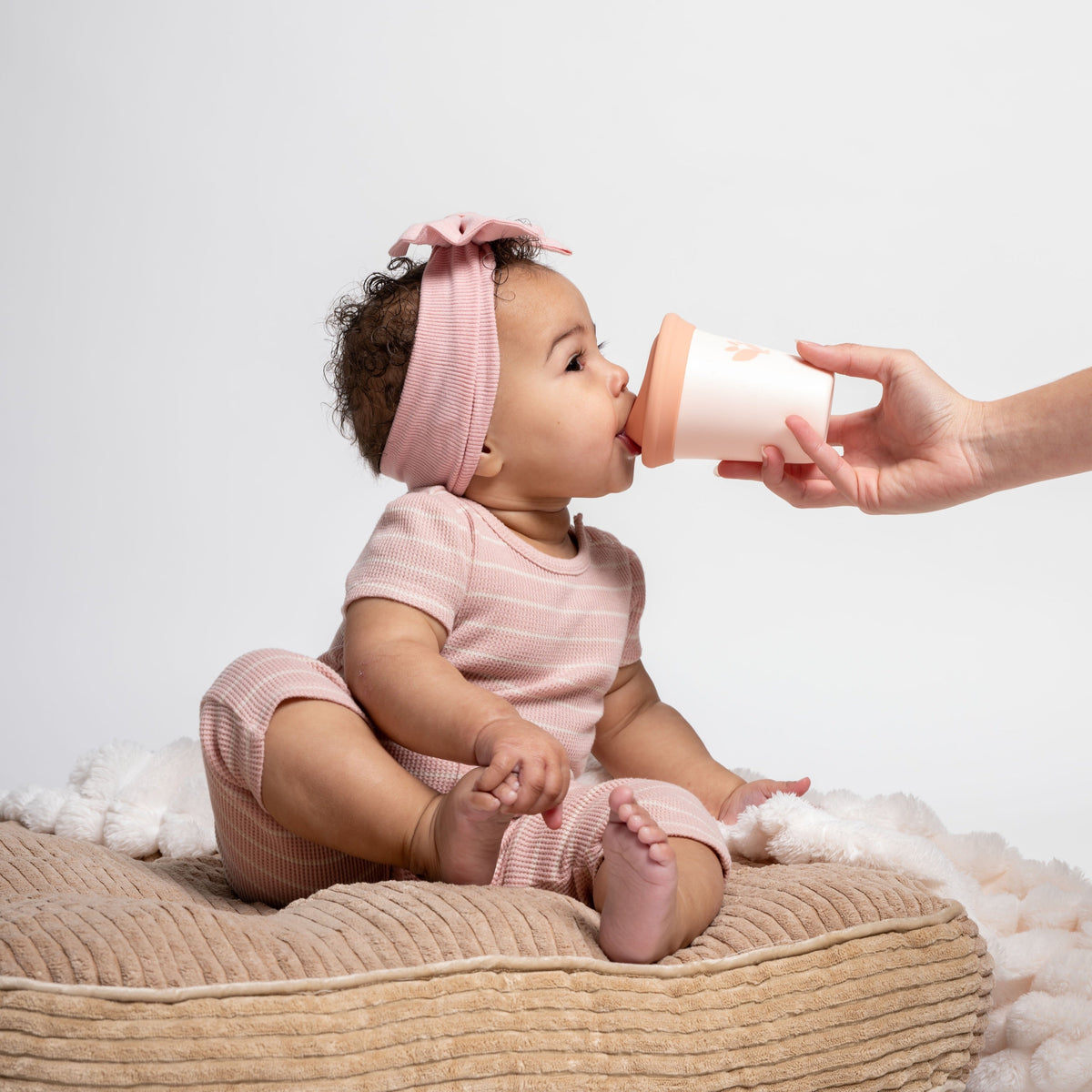 baby drinking from sippy cup, hand holding cup