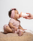 baby drinking from sippy cup, hand holding cup