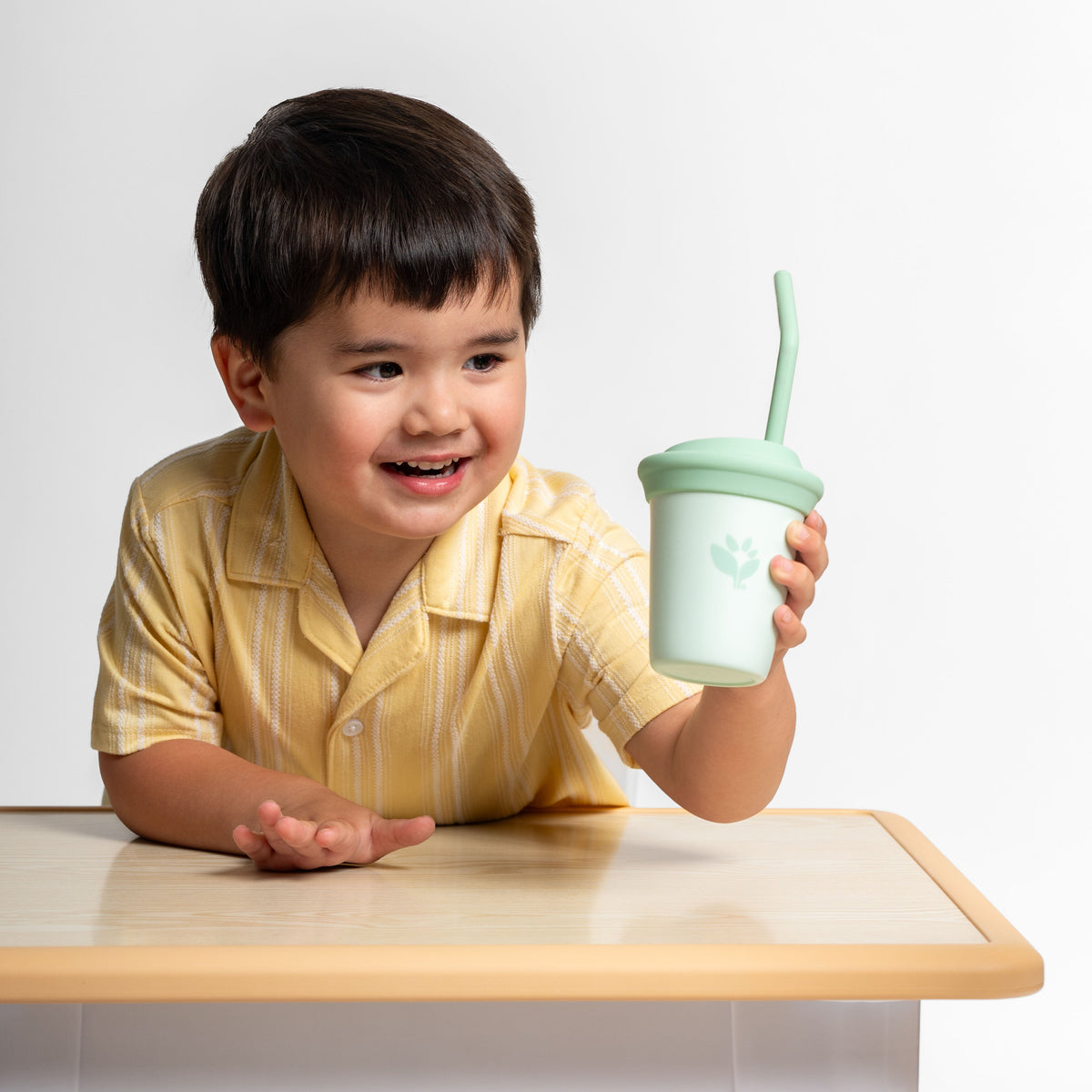toddler holding green sprouts my first straw cup