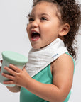 baby holding green sprouts 360 training cup and laughing