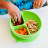 Little hands reaching into the green Learning Bowl made from Silicone