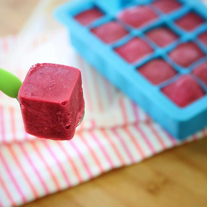 The yummy rasperberry puree frozen cube on a spoon with the aqua Fresh Baby Food Freezer Tray.