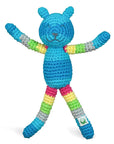 A blue and striped rainbow patterned rattle crocheted to look like a raccoon.
