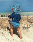 young baby standing on the beach looking a the waves while wearing a Navy Long Sleeve Rashguard Shirt